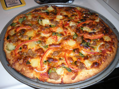 Pizza with spinach, veg sausage, red peppers and pineapple